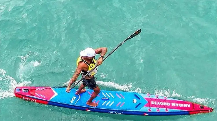 Man paddleboarding on a blue and red board with reinforced woven fabric in water