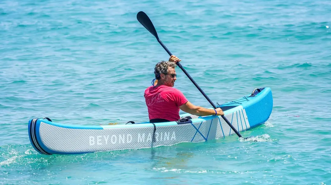 Blue and white inflatable kayak ideal for water activities like paddle boarding at the marina.