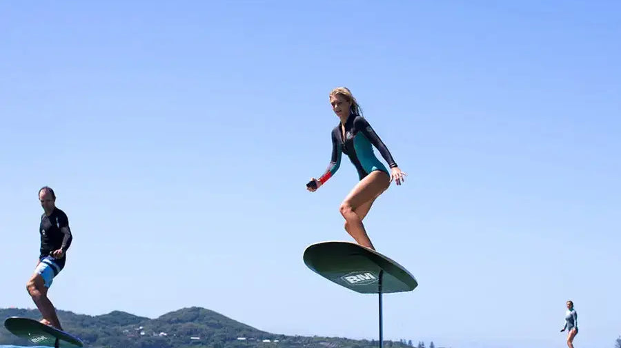 Person surfing on an AQUAGLIDE EFOIL, showcasing innovative hydrofoil technology.