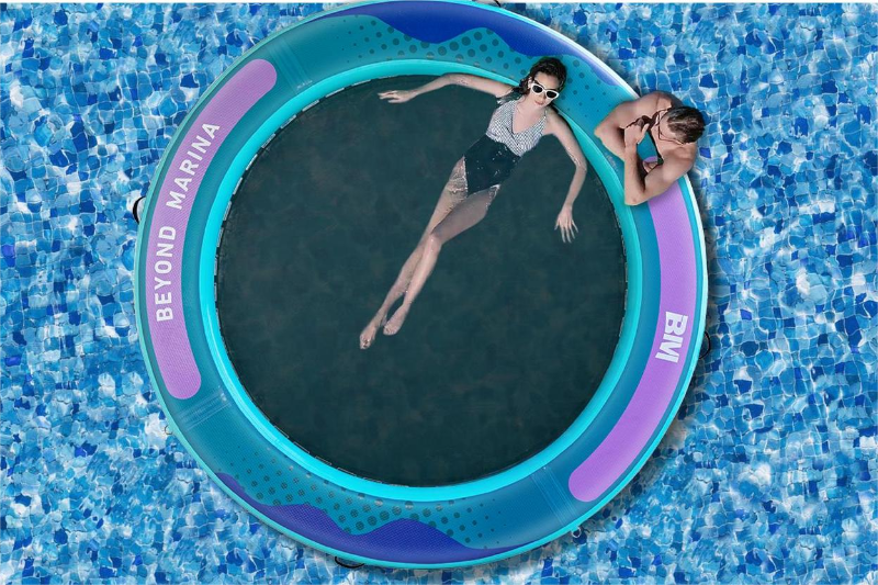 Two people lounging on a circular inflatable dock in a pool.