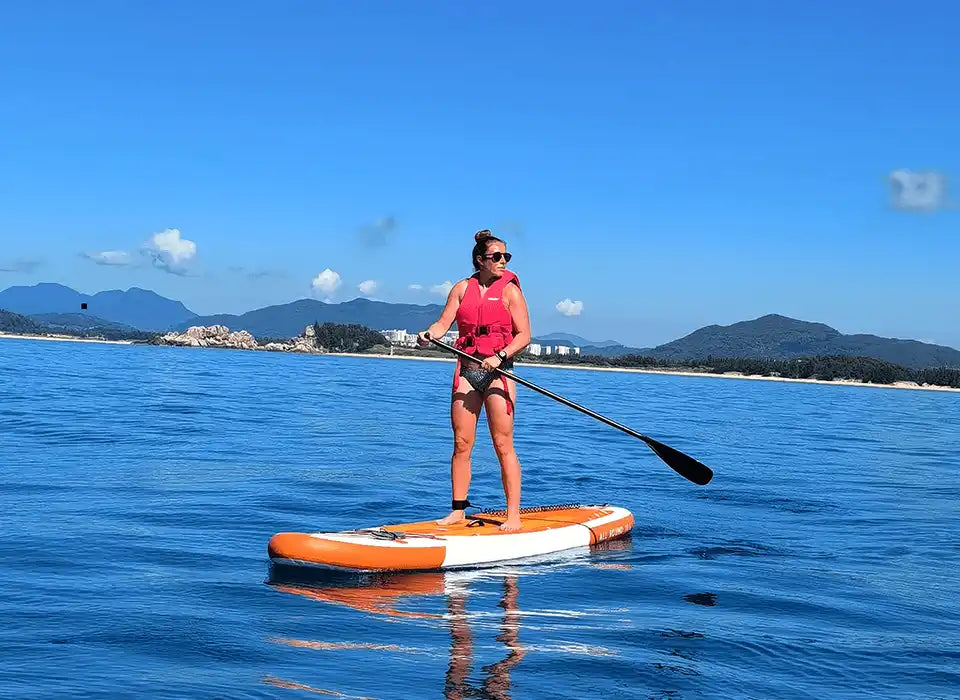 Woman paddleboarding on a calm sea.