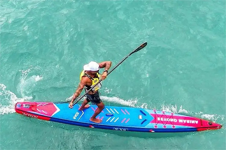 Man paddleboarding on a blue and red board with reinforced woven fabric in water