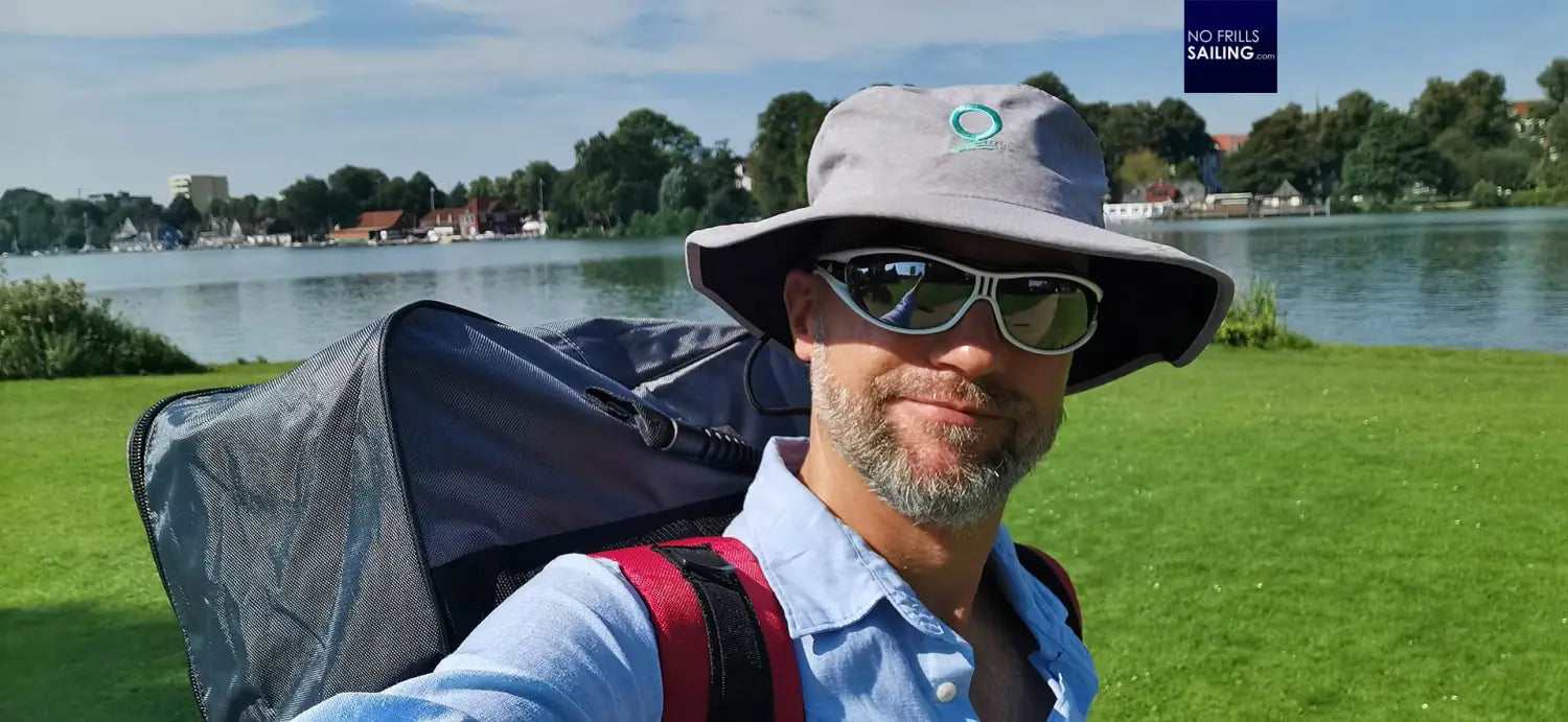 Man with backpack and sunglasses taking a self camera on a stand-up paddleboard