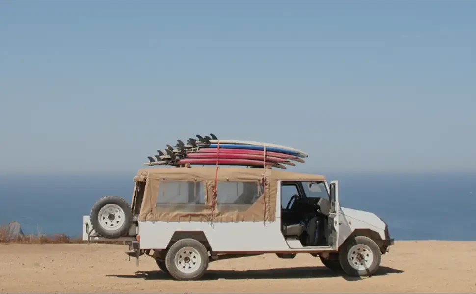 White jeep with surfboards on top, perfect for transporting inflatable lure boats