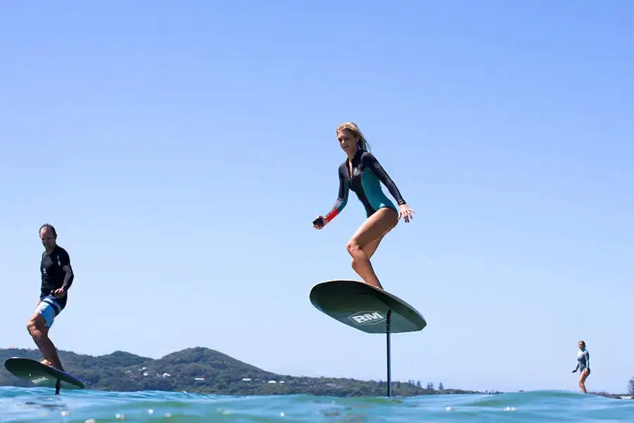 Person surfing on an AQUAGLIDE EFOIL, showcasing innovative hydrofoil technology.