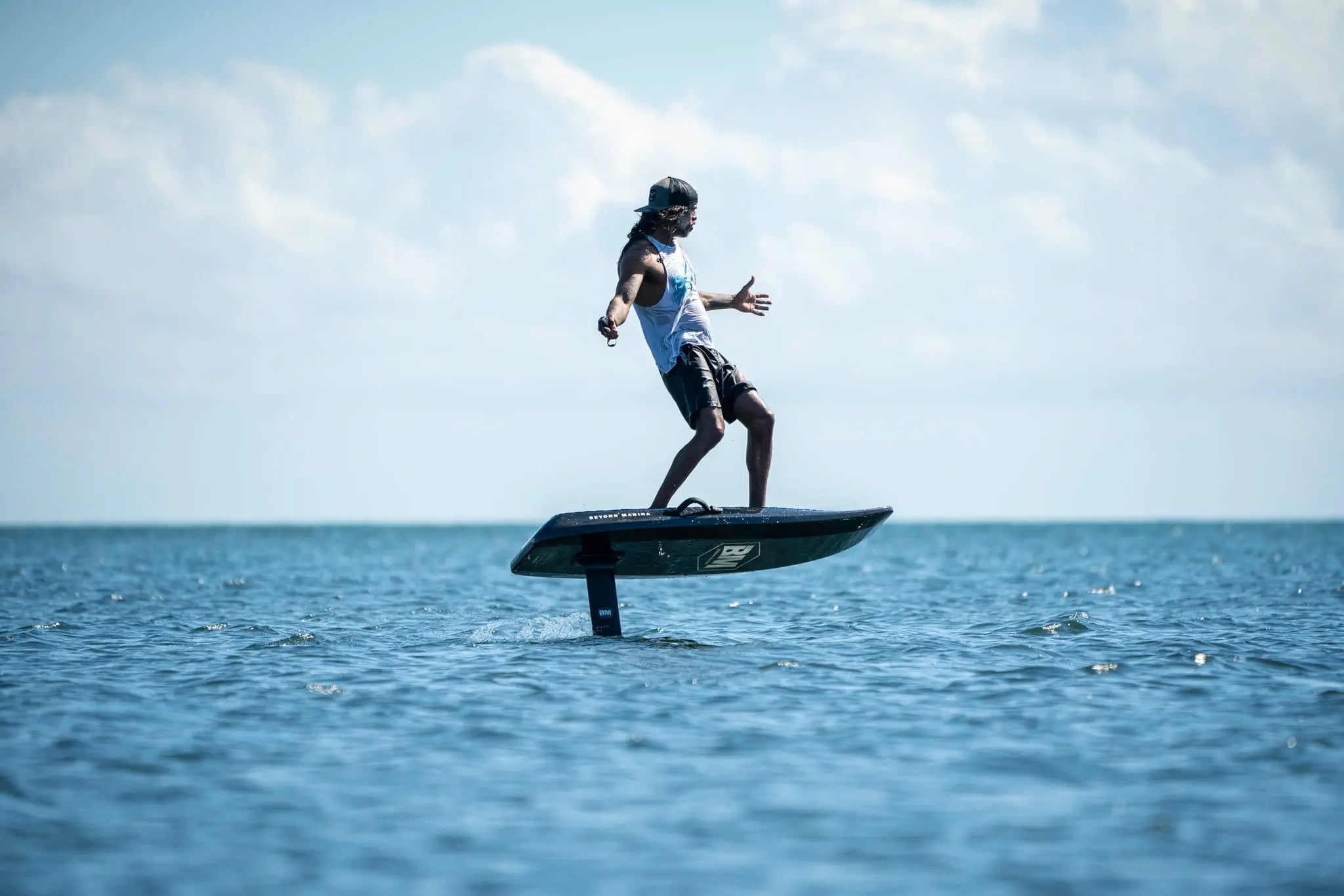 Person on a hydrofoil board in the ocean with a clear sky