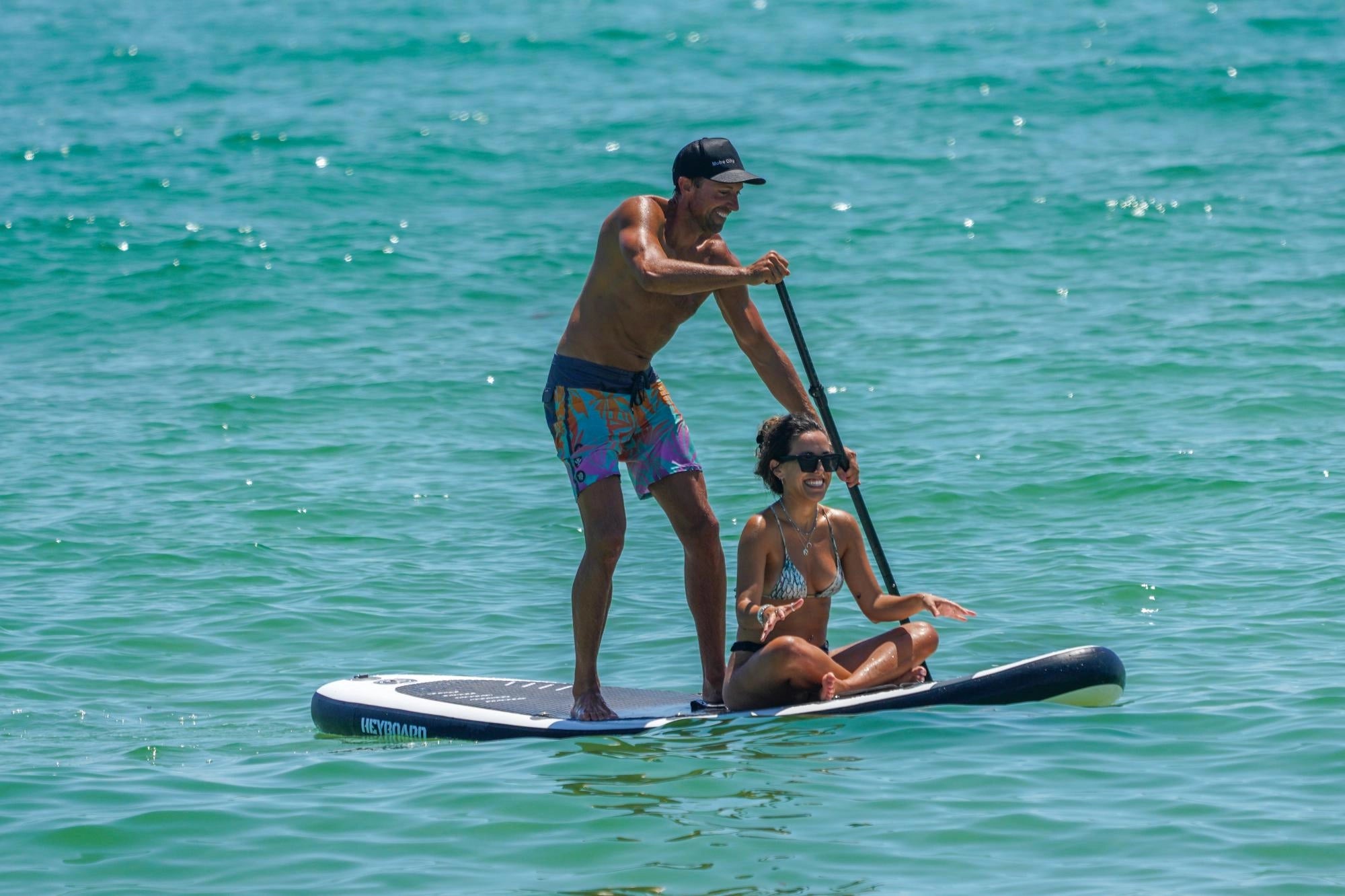 Two people on a stand up paddle board in the ocean