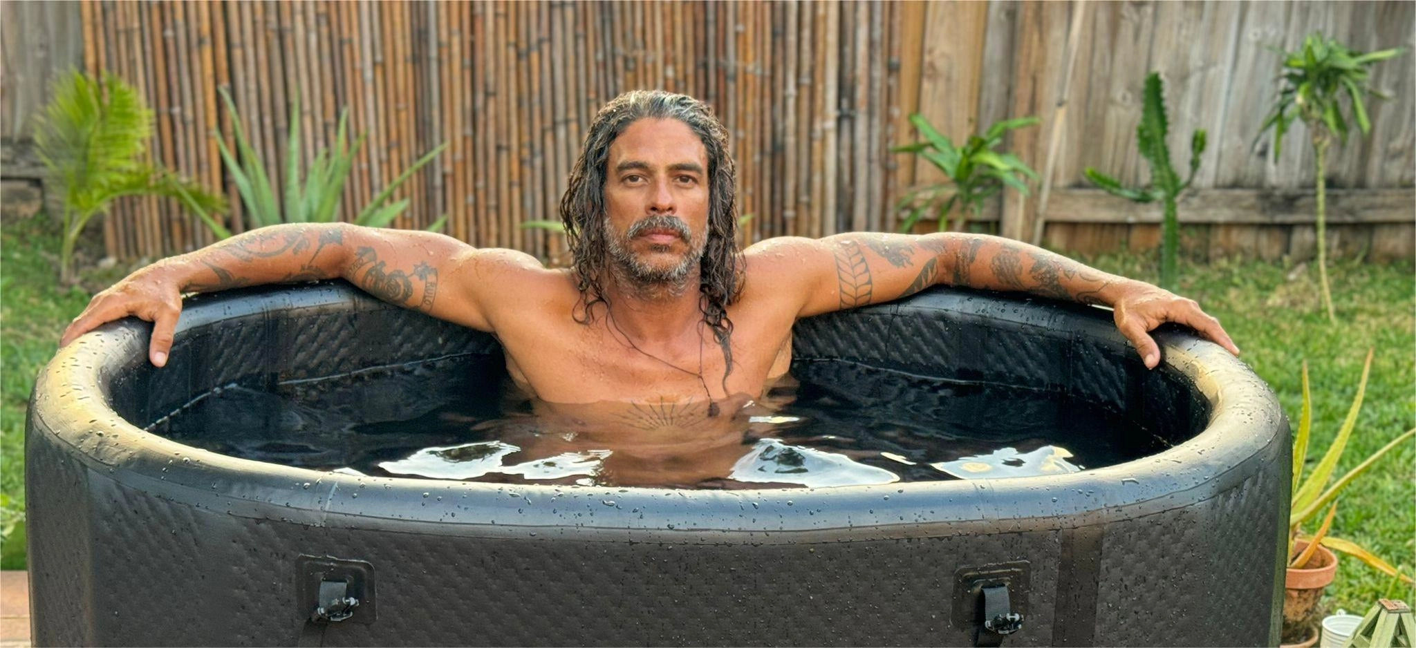 Man relaxing in a cold plunge tub outdoors