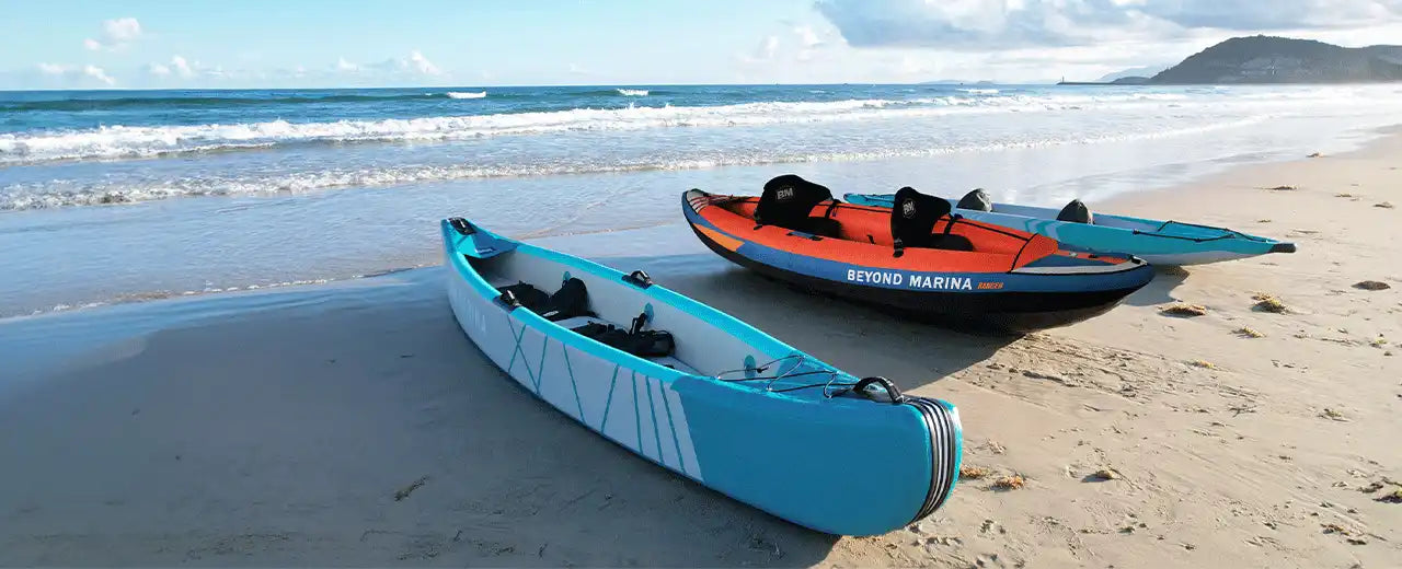 Inflatable kayaks on sandy beach.