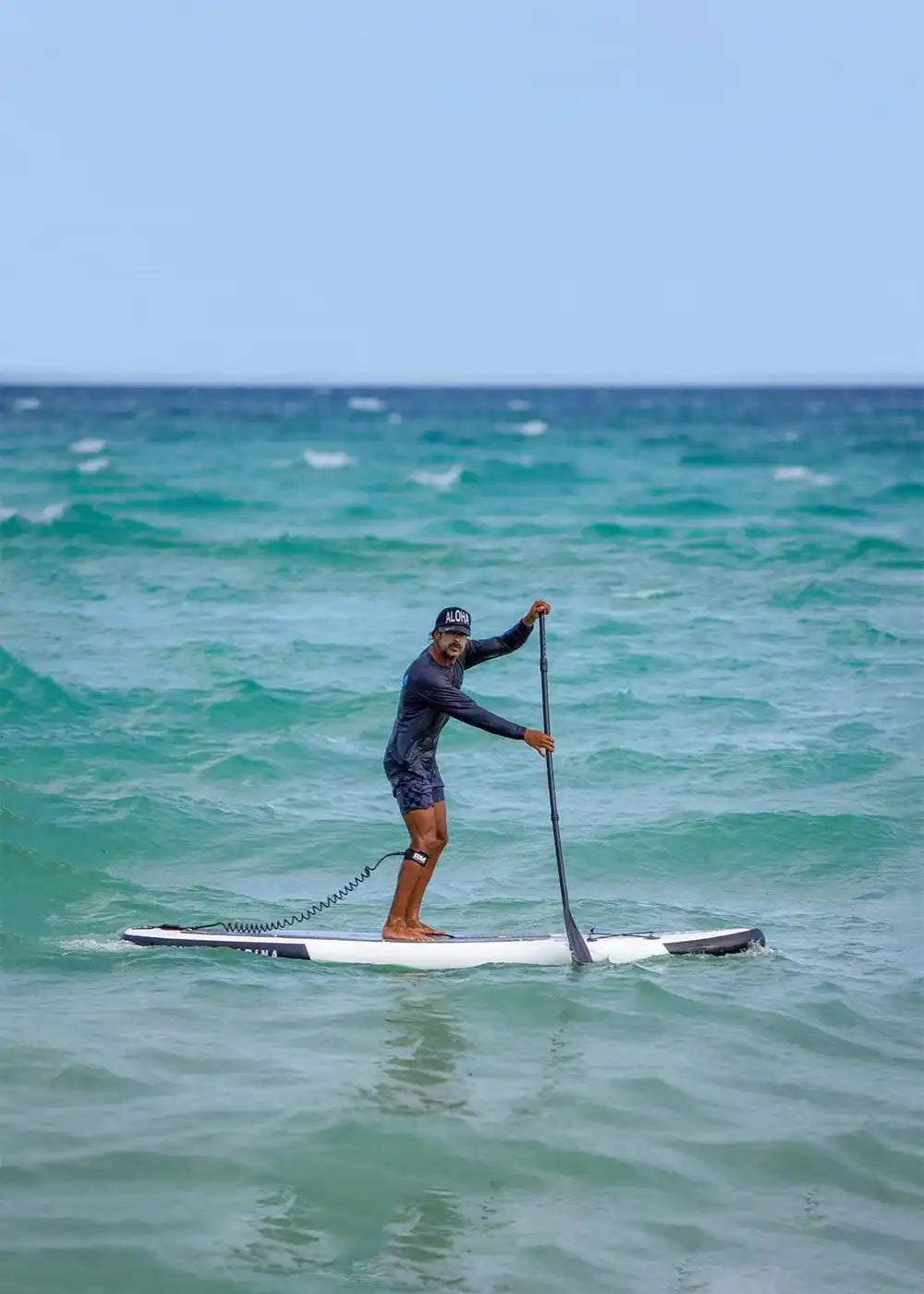 Man paddleboarding in ocean.