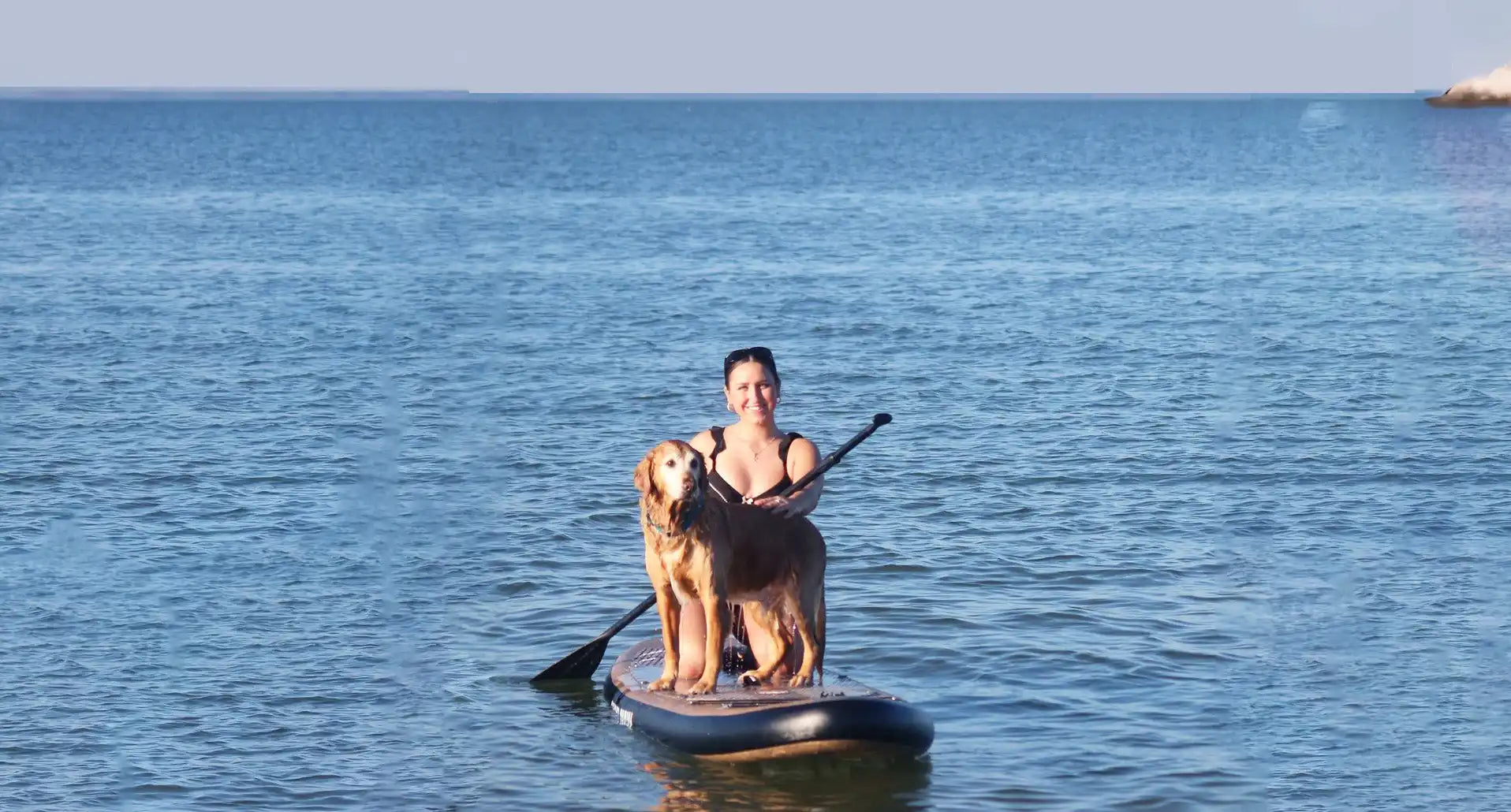 Woman and dog paddleboarding.